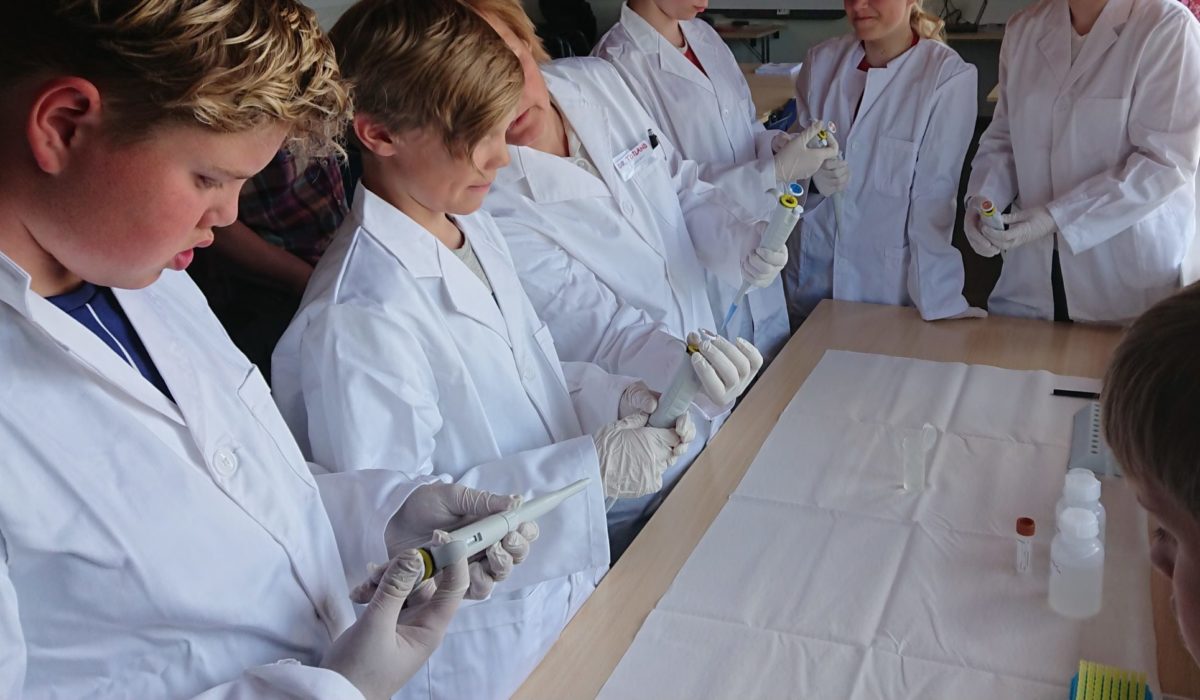 Elever i labfrakker under forskerlaben