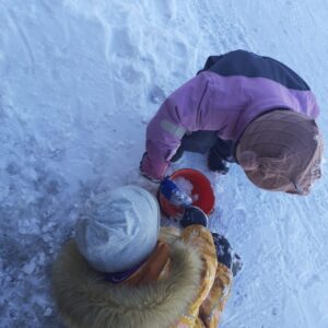 Barnehagebarn leker med snø